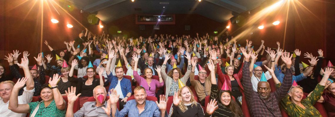 Corporate event, group picture of people cheering in a cinema during World Cinema Amsterdam festival.