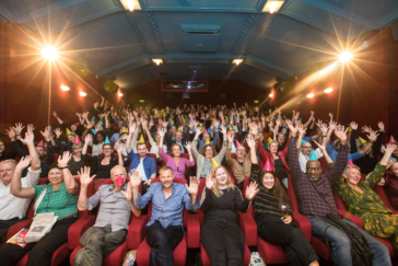 Corporate event, group picture of people cheering in a cinema during World Cinema Amsterdam festival.
