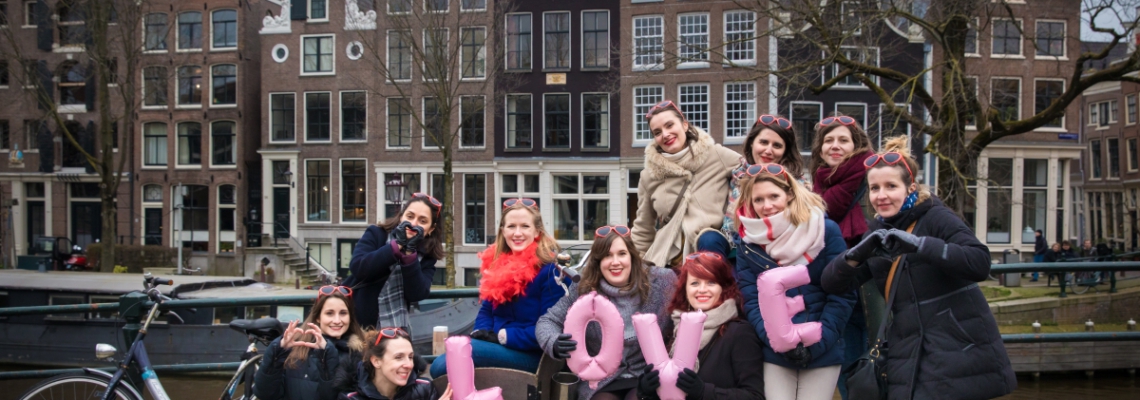 Bachelorette party photography EVJF, friends posing with balloon letters saying LOVE, having a good time, laughing and celebrating the bride-to-be, Brouwersgracht, Amsterdam
