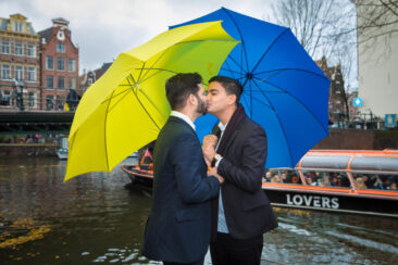 Wedding photography, elopement photographer, engagement and proposal photography, couple photoshoot, romantic photo of a gay couple kissing under colourful umbrellas, Brouwersgracht, Amsterdam
