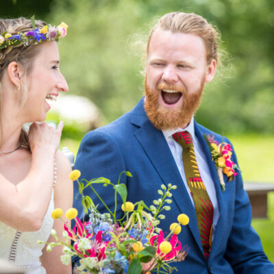 Bruidsfotograaf en trouwfotograaf, colourful wedding photography, the groom and bride are giving each other a knowing look and laughing during the wedding ceremony, Zeeland, Landgoed Twistvliet, Vrouwenpolder, The Netherlands