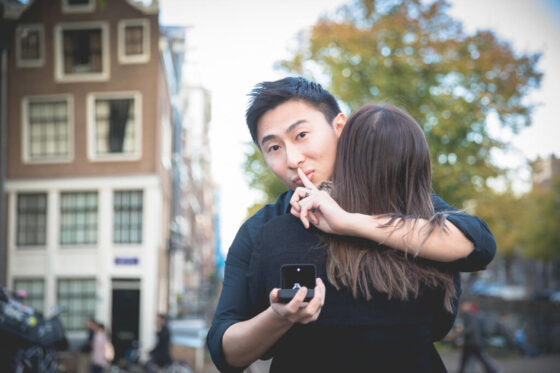 Couple photography, loveshoot, engagement photography, proposal photography Amsterdam, Portrait of an Asian man about to propose to his fiancée holding an engagement ring during his secret proposal in Amsterdam