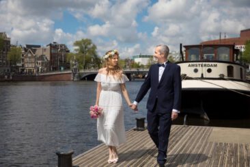 Wedding photography, bride photography, elopement photographer, couple photoshoot, romantic photo of a bride and groom walking hand in hand, during their elopement marriage, Amstel River, Amsterdam