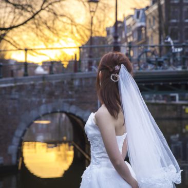 Wedding photography, elopement photographer, engagement and proposal photography, couple photoshoot, a bride is looking at the romantic canal Brouwersgracht at sunset, during her elopement, Amsterdam