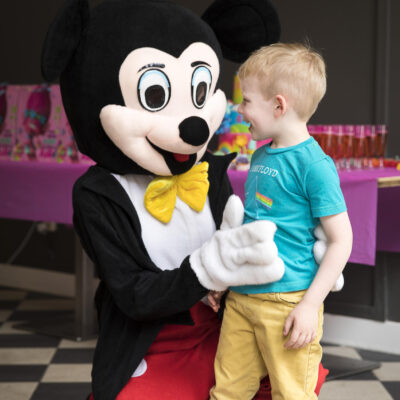 Birthday party photographer, portrait of a young boy having fun with Mickey Mouse at a birthday party in Amsterdam