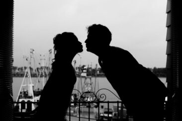 Bruidsfotograaf, trouwfotograaf, Wedding photography, bride photography, elopement photographer, marriage photography, black and white silhouette of a couple, bride and groom, kissing with the port of Zoutkamp in the background, The Netherlands