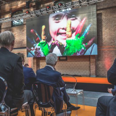 Corporate event photography, audience of men watching a video about inclusivity at the Dutch Transformation Forum in den Haag