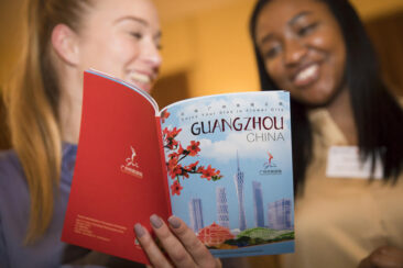 Corporate event photography, conference photography, 2 young ladies are looking and discussing a touristic brochure of Guangzhou China, Utrecht