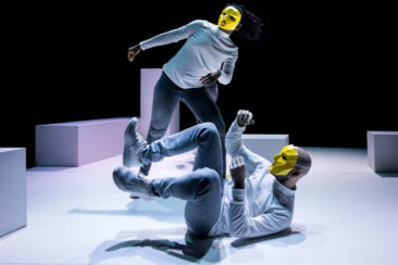 Event photography, festival photography, theatre photography, portrait of 2 comedians dancing, they are wearing yellow masks leaning towards the audience, Answers in Theater de Generator in Leiden