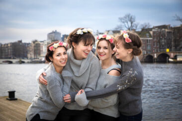 Bachelorette party photography EVJF, 4 friends on a pontoon by Hermitage, Amsterdam, having a good time hugging each other and laughing