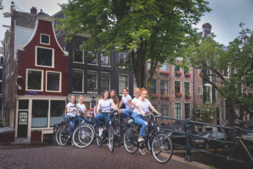 Bachelorette party photoshoot, EVJF, portrait of a group of friends on their bikes, celebrating the wife-to-be,, Reguliersgracht, Amsterdam