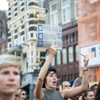 Journalistic photography, event photography, participant is holding a sign for gender fluidity at demonstration during Pink Saturday during Gay Pride, Amsterdam