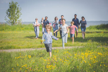 On-location family photoshoot, children Photoshoot, together with the family for a fun photo session, happy family is walking in the countryside on a sunny summer day, the children are running to the camera, Monnickendam