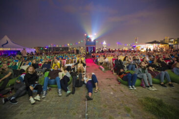 Festival photography, photo of the audience watching a movie at open-air film screening at Stenen Hoofd during Pluk de nacht festival, Amsterdam