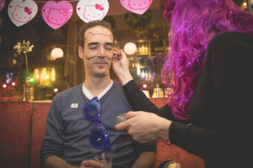 private photography, birthday photography, photo of a woman putting on some make-up, drawing a Hello Kitty shape on his face before a birthday party, Amsterdam