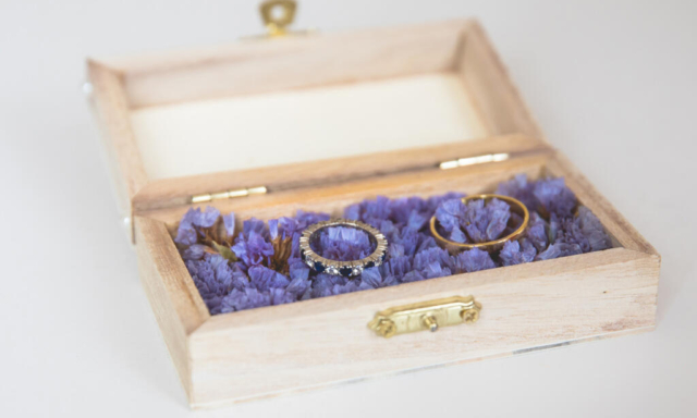 Wedding photography, elopement, zoom on the wedding rings presented in a lovely vintage wooden box on a bed of purple flowers, Amtserdam