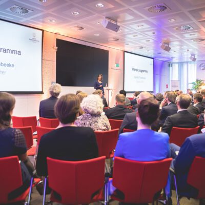 Corporate event photography, conference with a moderator speaking in front of an audience, Amsterdam