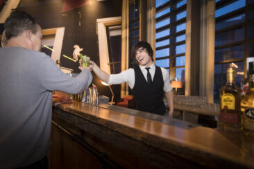 Lifestyle corporate photography, event photography, professional barman handing a cocktail to a client at Hyatt Place Jubilee Party, Amsterdam