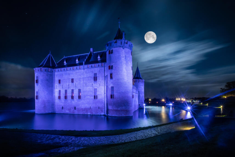 Landscape and nature photography, view of the tourist castle of Muiderslot at night with full moon, photo taken for illustration on website, brochure and social media