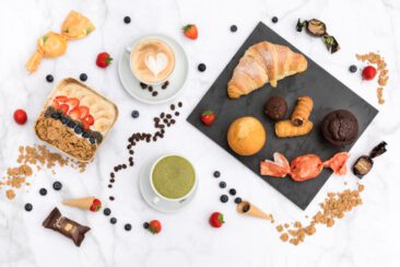 Food and restaurant photography, branding and product photography, hero shot of mouthwatering pastries, croissant, muffins, açaí bowl, chai, cappuccino on a marble background, Amsterdam