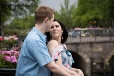 Couple photoshoot, loveshoot, engagement photoshoot, holiday photographer Amsterdam vacation photographer Amsterdam: portrait of a couple posing on a pontoon on the romantic canal Prinsengracht, looking at each other with love, Amsterdam