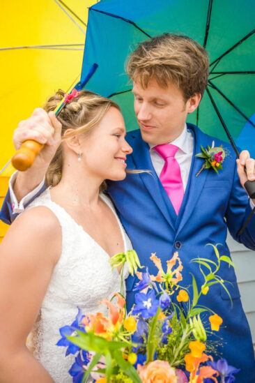 Bruidsfotograaf, trouwfotograaf, wedding photography, bride photography, elopement photographer, couple photoshoot, romantic photo of a bride and groom posing under colourful umbrellas, Zoutkamp, The Netherlands
