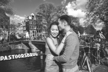 Couple photoshoot, loveshoot, engagement photoshoot, holiday photographer Amsterdam vacation photographer Amsterdam: black and white portrait of a couple posing in love by romantic canal Brouwersgracht, Amsterdam
