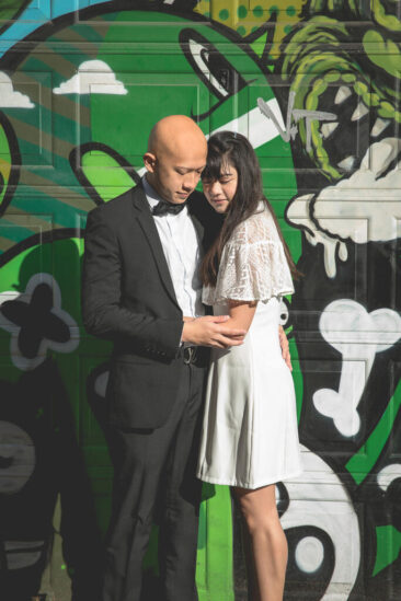 Couple photoshoot, loveshoot, engagement photoshoot: portrait of a couple in love posing in front of a graffiti wall in Amsterdam city centre