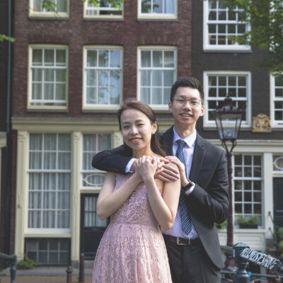 couple photography, portrait of an Asian man and woman posing in a romantic old city center street in Amsterdam