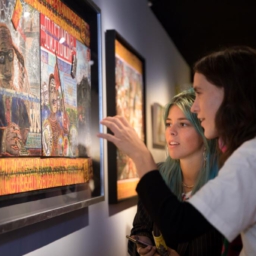 Cultural event photography, 2 young ladies are looking at an artwork during opening of exhibition Woest at Outsider Art Museum (Museum van de Geest | Outsider Art in Hermitage Amsterdam