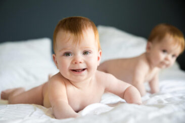 Baby photography, lifestyle photoshoot, family photoshoot, photo of 2 adorable twin babies playing around on their parent's bed, Amsterdam