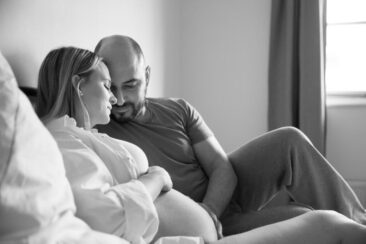 Maternity photographer, Pregnancy photography, lifestyle pregnancy photoshoot, romantic black and white photo of a pregnant couple chilling at home on their bed, Hilversum