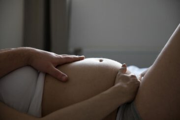 Maternity photographer, Pregnancy photography, photo zooming on a pregnant lady's belly with her husband's hand, Hilversum