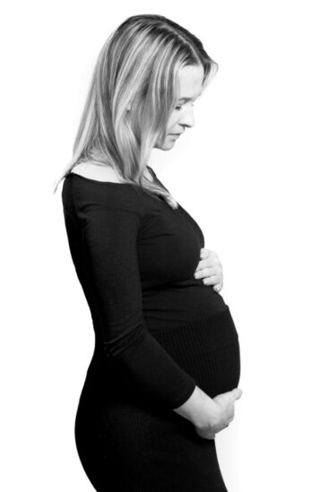 Maternity photographer, Pregnancy photography, black and white photo of a pregnant lady holding her baby bump, Hilversum