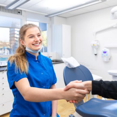 Lifestyle corporate photography, portrait of a professional dentist greeting a patient at her practice, in Amsterdam