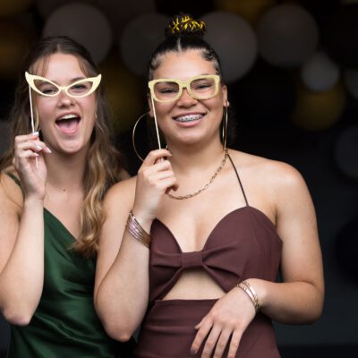 Party photography, young ladies taking a funny pose at a graduation gala party, the Netherlands