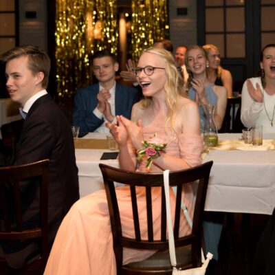 Party photography, young people are cheering and clapping during diner at a graduation gala party, the Netherlands