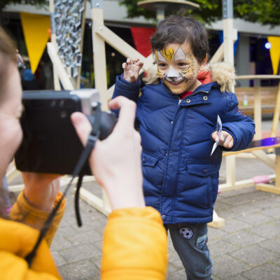 Festival photography, portrait of a young boy with lion face make-up being photographed by another person during Vrijheidsmaaltijd, WOW, Amsterdam