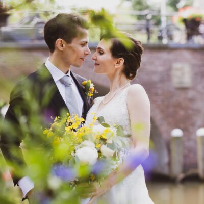 Wedding photography, romantic photo of bride and groom by a canal in old city centre, Utrecht, Netherlands