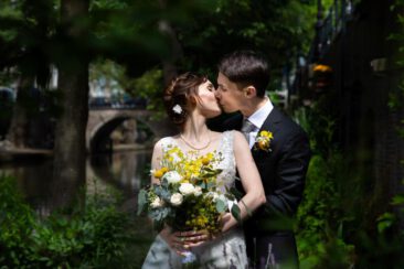 Wedding photography, bride photography, elopement photographer, couple photoshoot, a couple, bride and groom, is kissing near a green and romantic canal in Utrecht