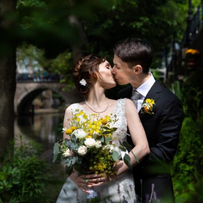 Wedding photography, photo of bride and groom kissing by a canal in old city centre, Utrecht, Netherlands