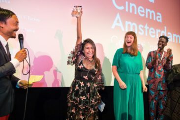 Corporate event photography, festival photography, award ceremony, the winner is cheering with her trophy, World Cinema Amsterdam