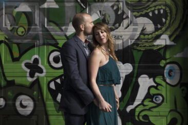 Couple photoshoot, loveshoot, engagement photoshoot: portrait of a couple posing in front of a graffiti wall in Amsterdam city centre