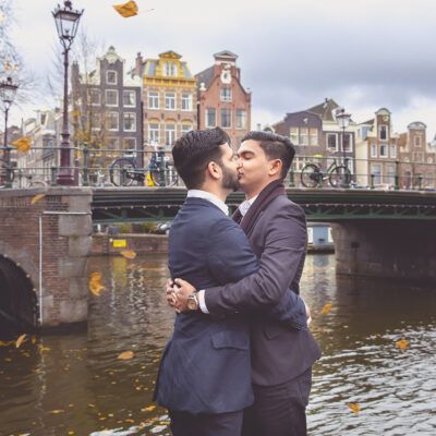 Proposal photography, couple photography, portrait of a man is hugging and kissing his boyfriend during an autumn loveshoot on a pontoon by Brouwersgracht, Amsterdam