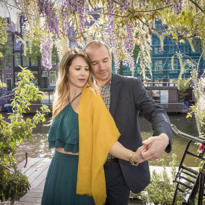 Proposal photography, couple photography, portrait of a man and a woman posing, looking at the engagement ring, under a wisteria by romantic canal, Prinsengracht, Amsterdam