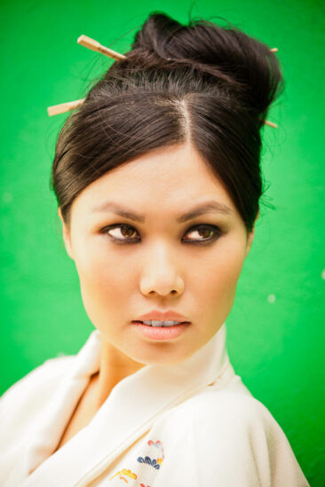 solo portrait, headshot, solo portrait of a young Asian woman on a green background, Amsterdam