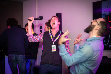 Corporate event photographer, Corporate party photography, 2 colleagues are celebrating and singing at a karaoke during Spotify conference, Stockholm, Sweden