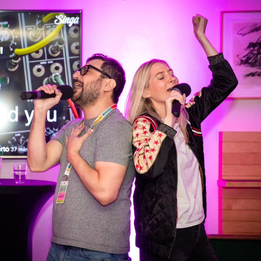 Corporate event photographer, Corporate party photography, 2 colleagues are celebrating and singing at a karaoke during Spotify conference , Stockholm, Sweden