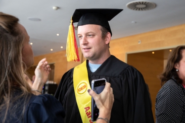 Corporate event photography, conference photography, graduate is getting ready before the ceremony during DHL CEM Graduation Amsterdam