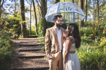Couple photoshoot, loveshoot, engagement photoshoot: portrait of a couple is posing under an umbrella saying "love is in the air" in Keukenhof Garden, The Netherlands